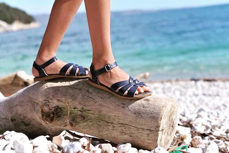 woman on beach in black sandals