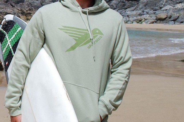 Man in pale green hoodie with surf board